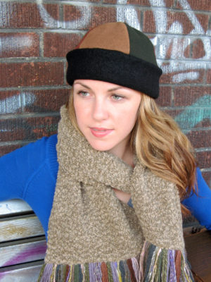 A woman sitting on a bench wearing a brown olive bean hat.