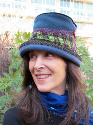 A close up of woman wearing a Estonian Hat in the colours blue and green.