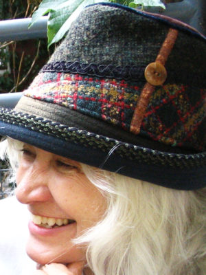 Close up of a happy client woman wearing her new dark green Estonian Hat.